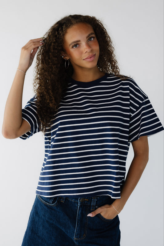 Teen age girl wearing a modest navy & white stripe loose fitting tee with short sleeves.