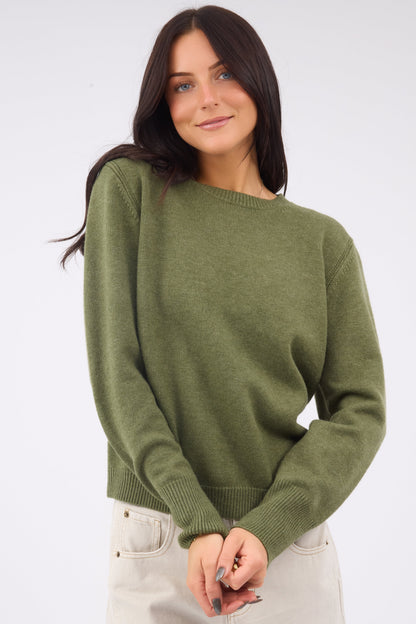 A young woman wearing a modest classic crewneck sweater with long sleeves.