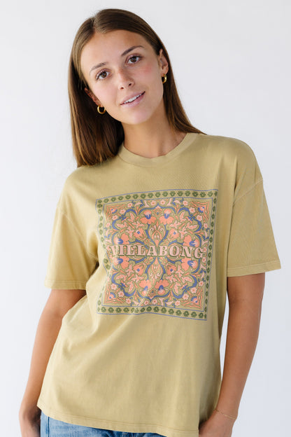 Young woman wearing a modest light mustard,  graphic tee by Billabong.