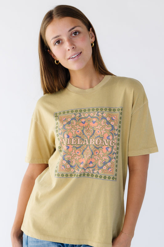 Young woman wearing a modest light mustard,  graphic tee by Billabong.