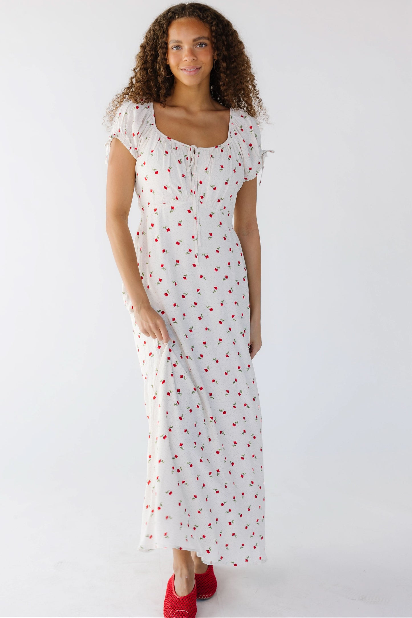Teenage girl wearing a close fitting white midi-maxi dress with short puff sleeves and a square-scoop neckline.