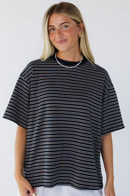 Young woman wearing a loose fitting stripe tee with short sleeves and a crew neckline.