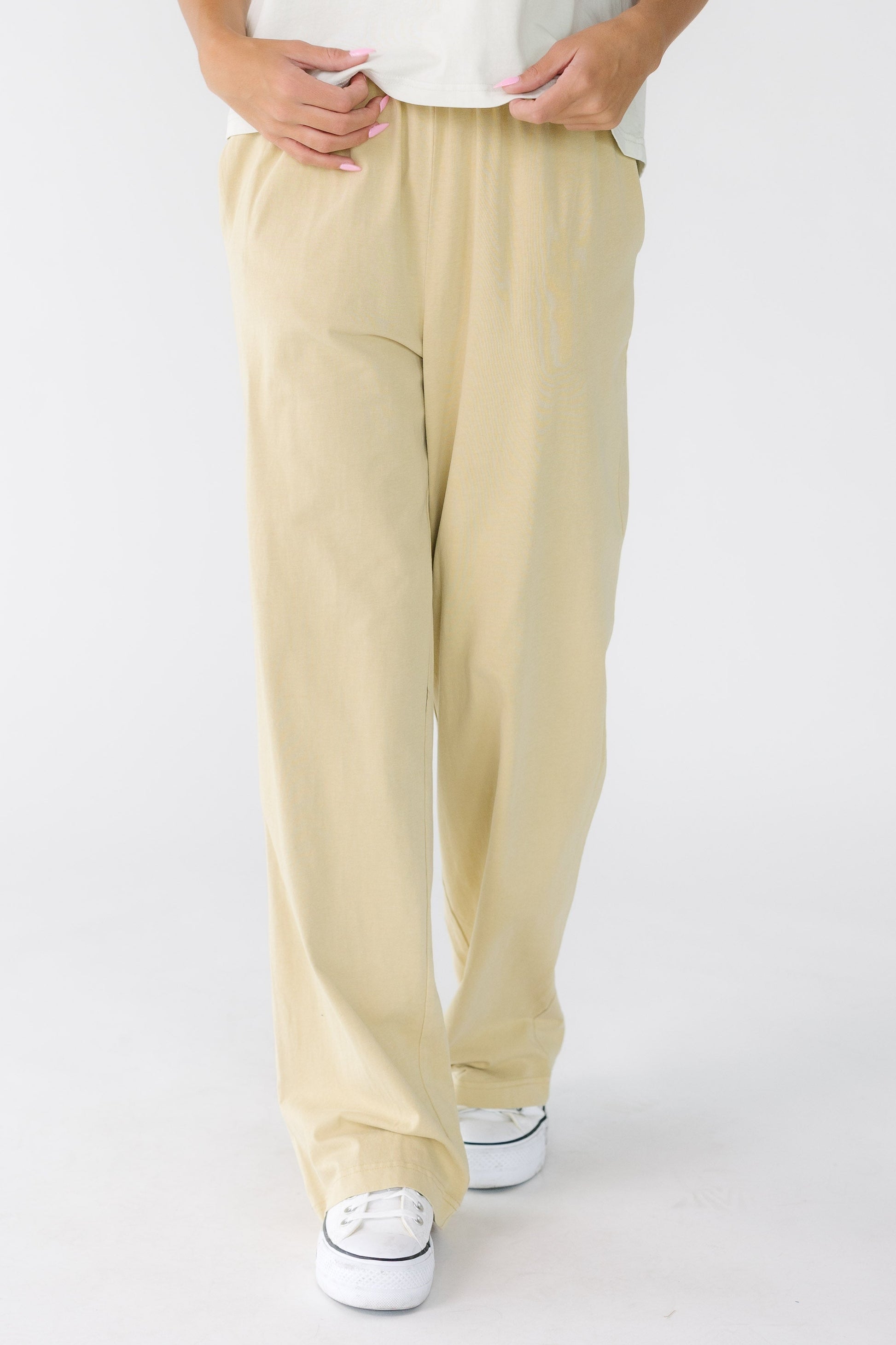 Woman wearing a pair of modest wide leg pants with elastic waist and side pockets.