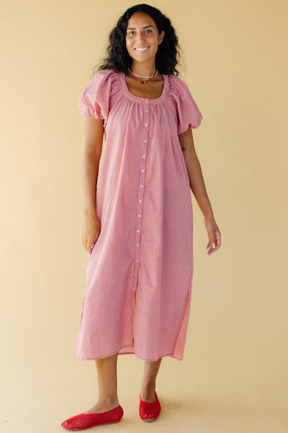 Young woman wearing a modest red & white gingham button down midi dress with side slits, balloon sleeves and side pockets.