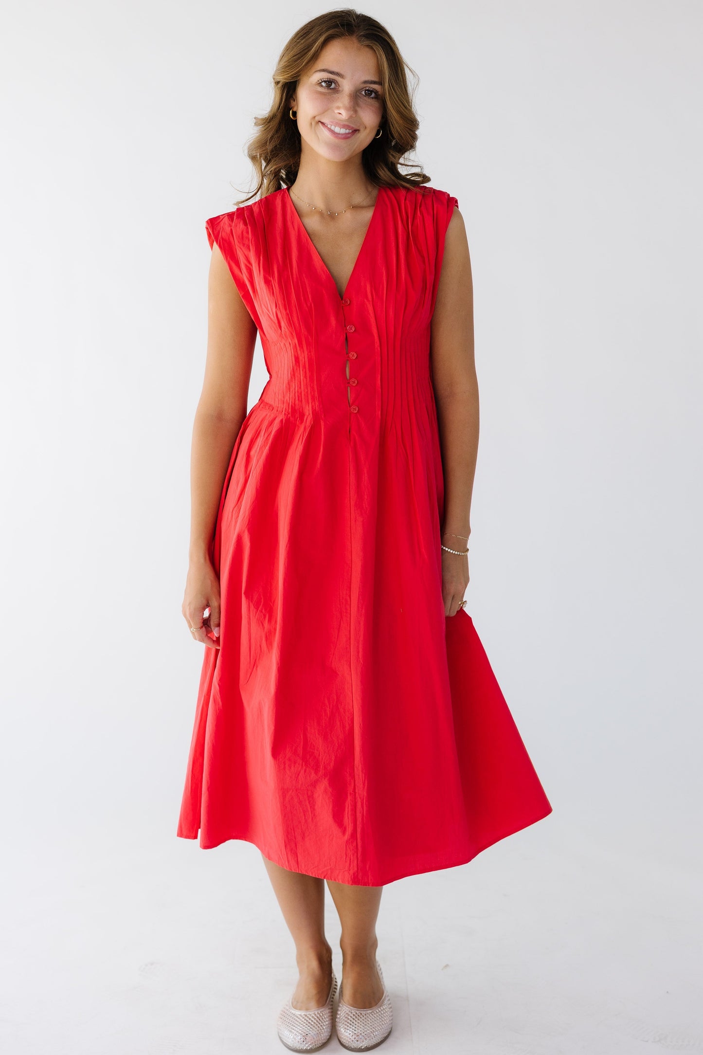 A sophisticated red sleeveless midi dress with pleats all around the waist.