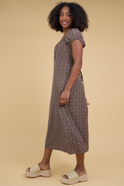 Side view of a woman wearing a slightly loose fitting midi dress with puff sleeves.