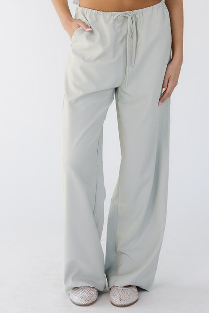 Teenage girl wearing modest taupe-grey wide leg pants with an elastic & drawstring waist and side pockets.