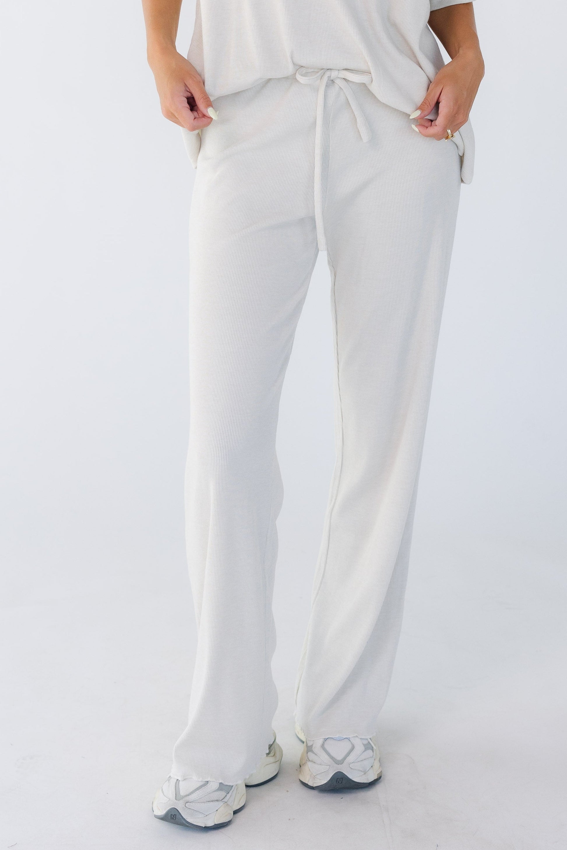 Young woman wearing a pair of modest beige wide leg lounge pants.