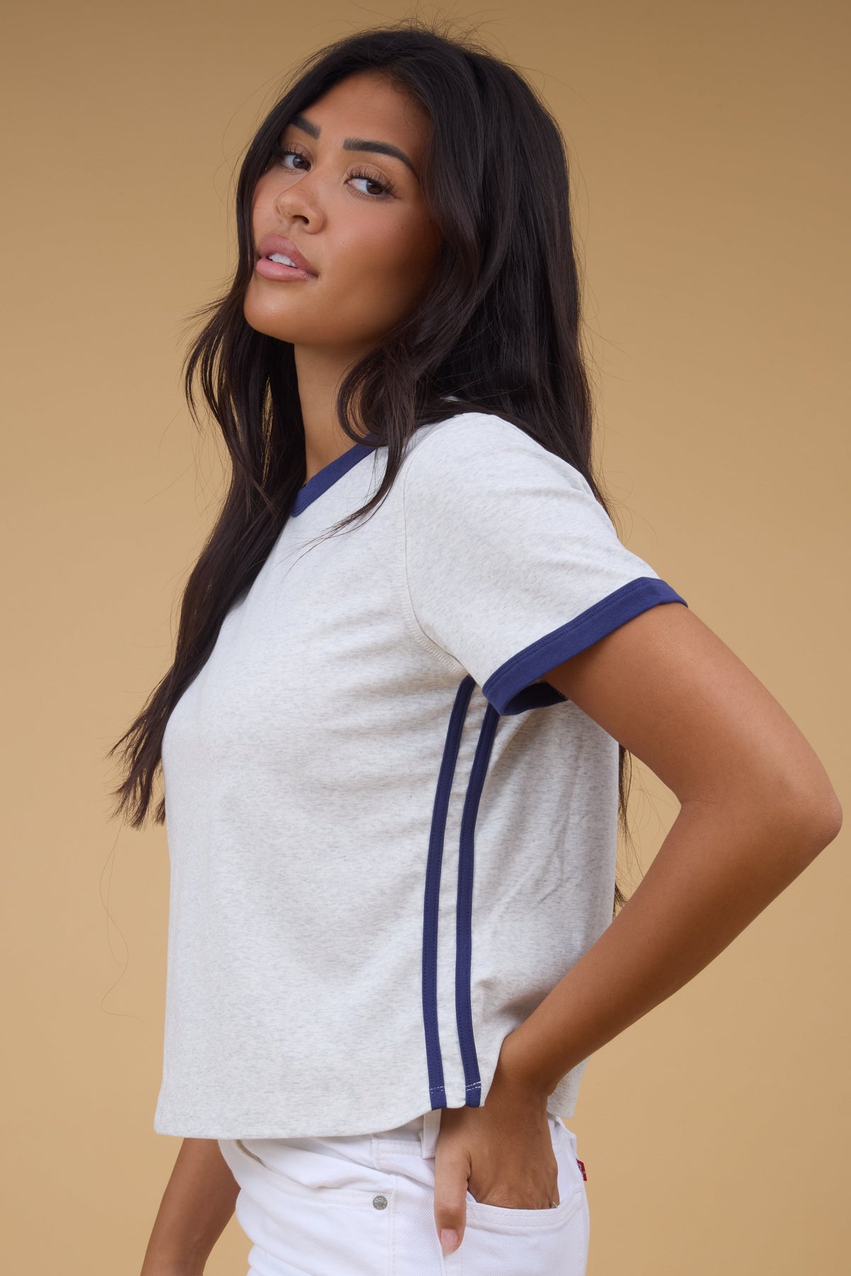 Woman wearing a grey tee with navy double side stripe and navy sleeve cuffs and neckline.