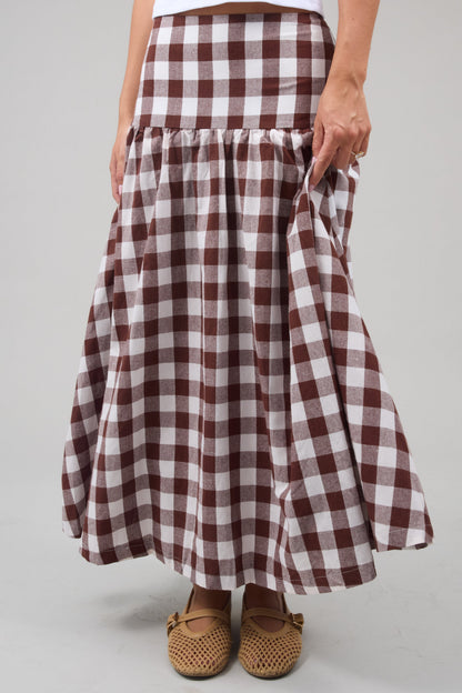 Young woman wearing a modest drop waist midi skirt in a large brown & white gingham.