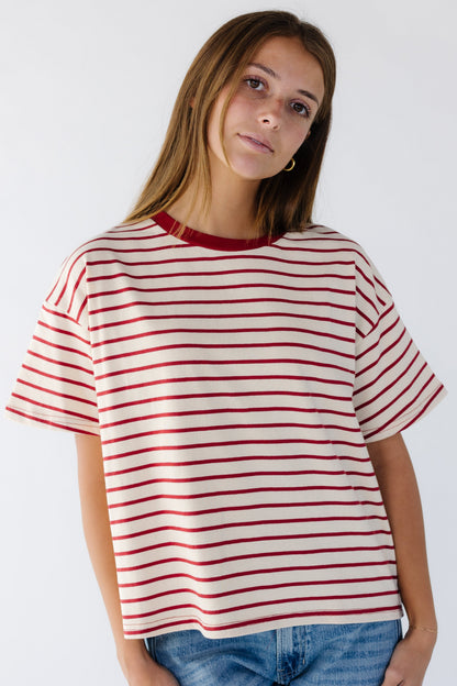 Woman wearing a cream and red stripe loose fitting tee with short sleeves.