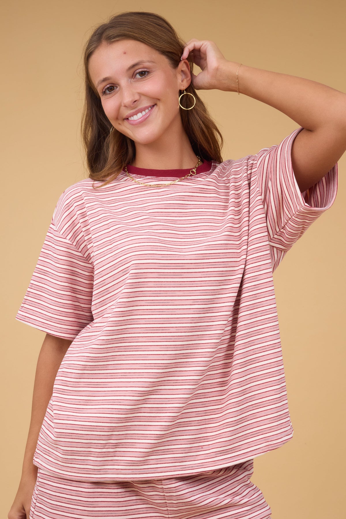 Young woman wearing a modest short sleeve plush knit stripe top with a crew neckline.