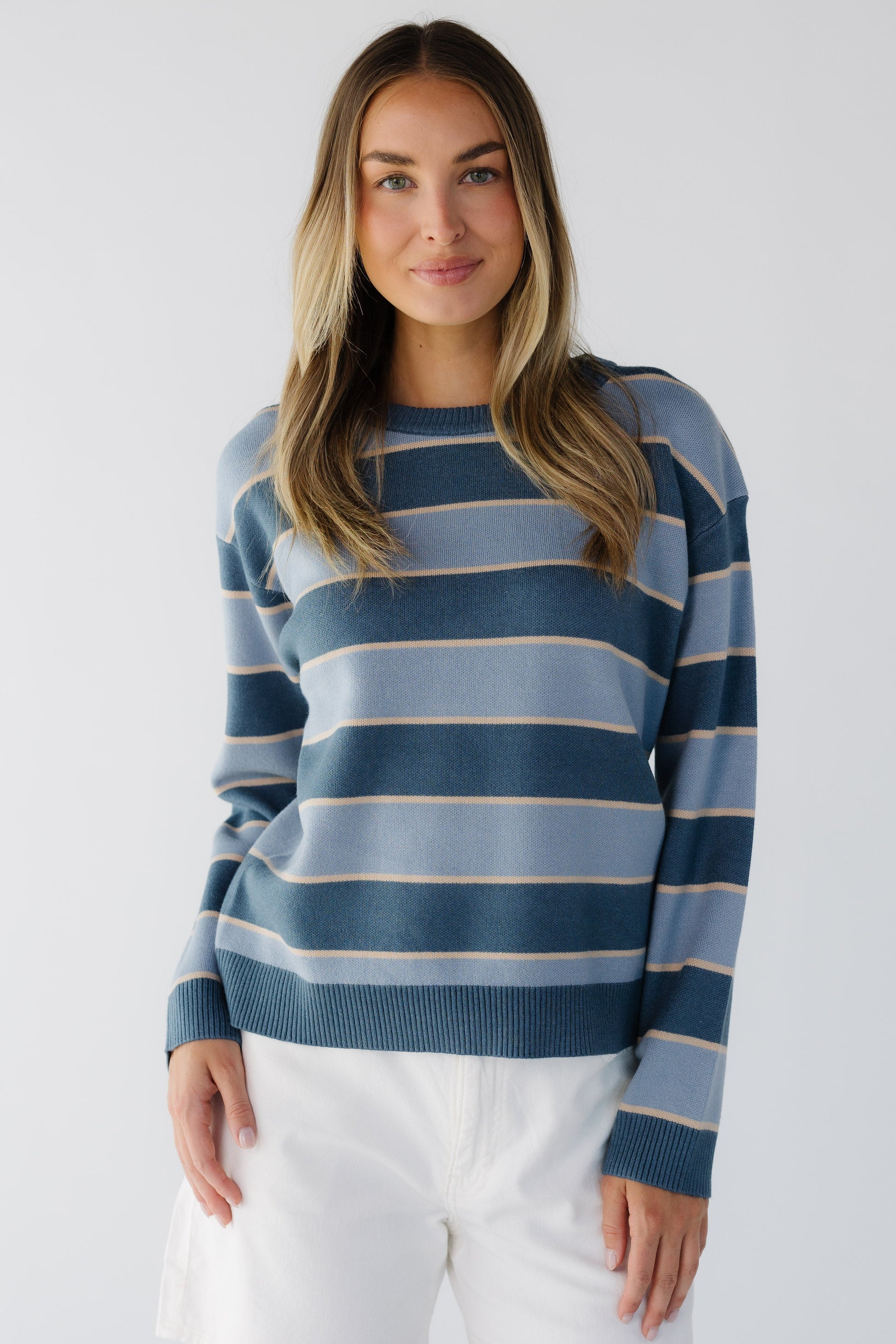 Young woman wearing a modest blue stripe long sleeve sweater with a crew neckline.