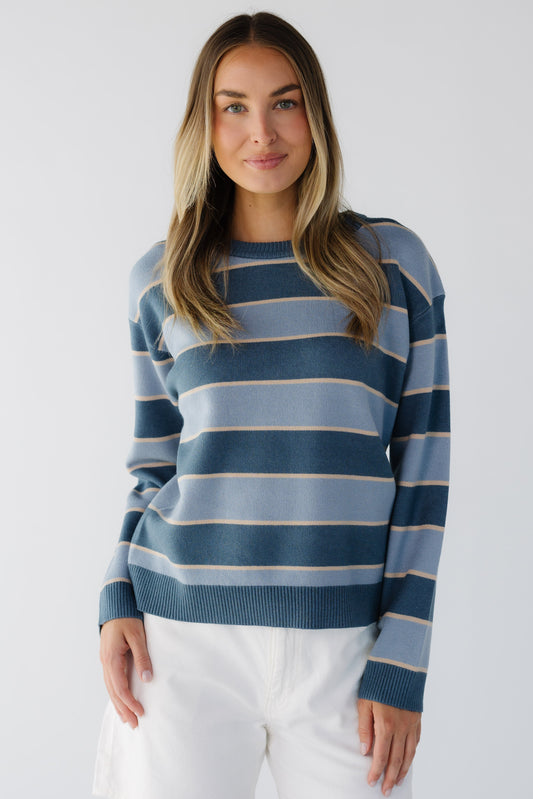 Young woman wearing a modest blue stripe long sleeve sweater with a crew neckline.