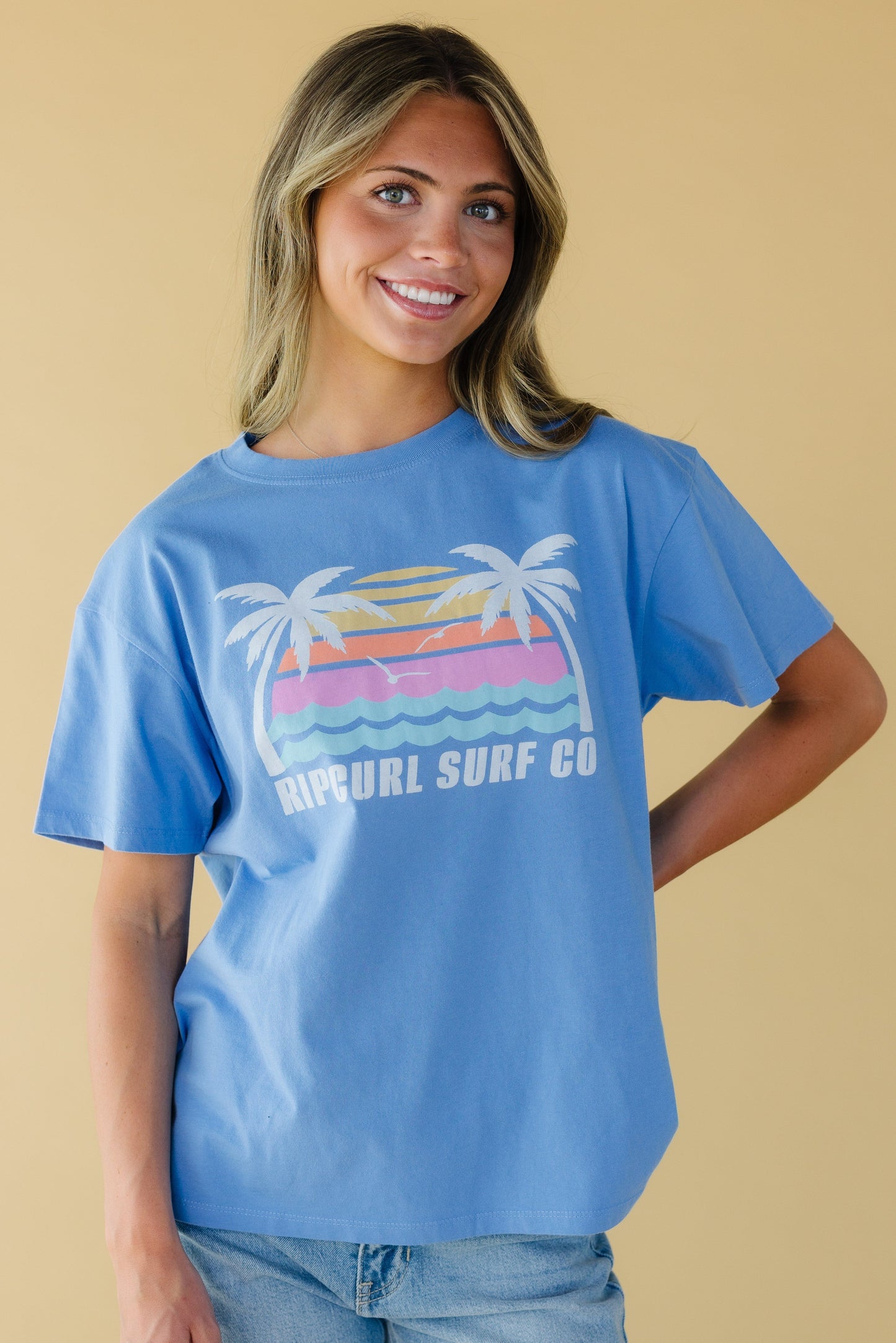 Woman wearing a Rip Curl graphic tee in blue with short sleeves and a crew neckline.