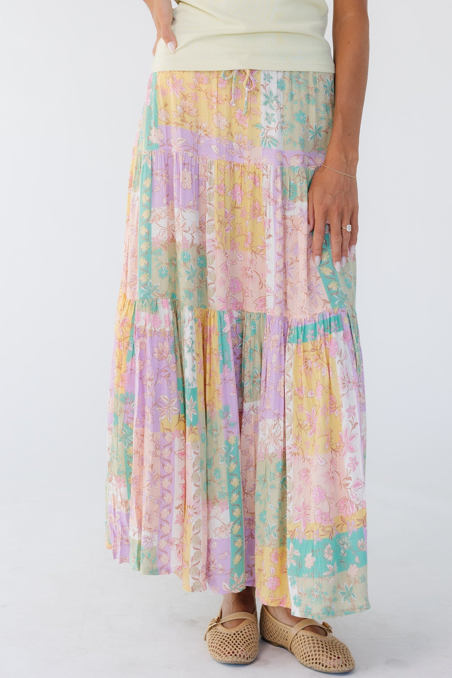 Woman wearing a multicolor pastel tiered midi skirt.
