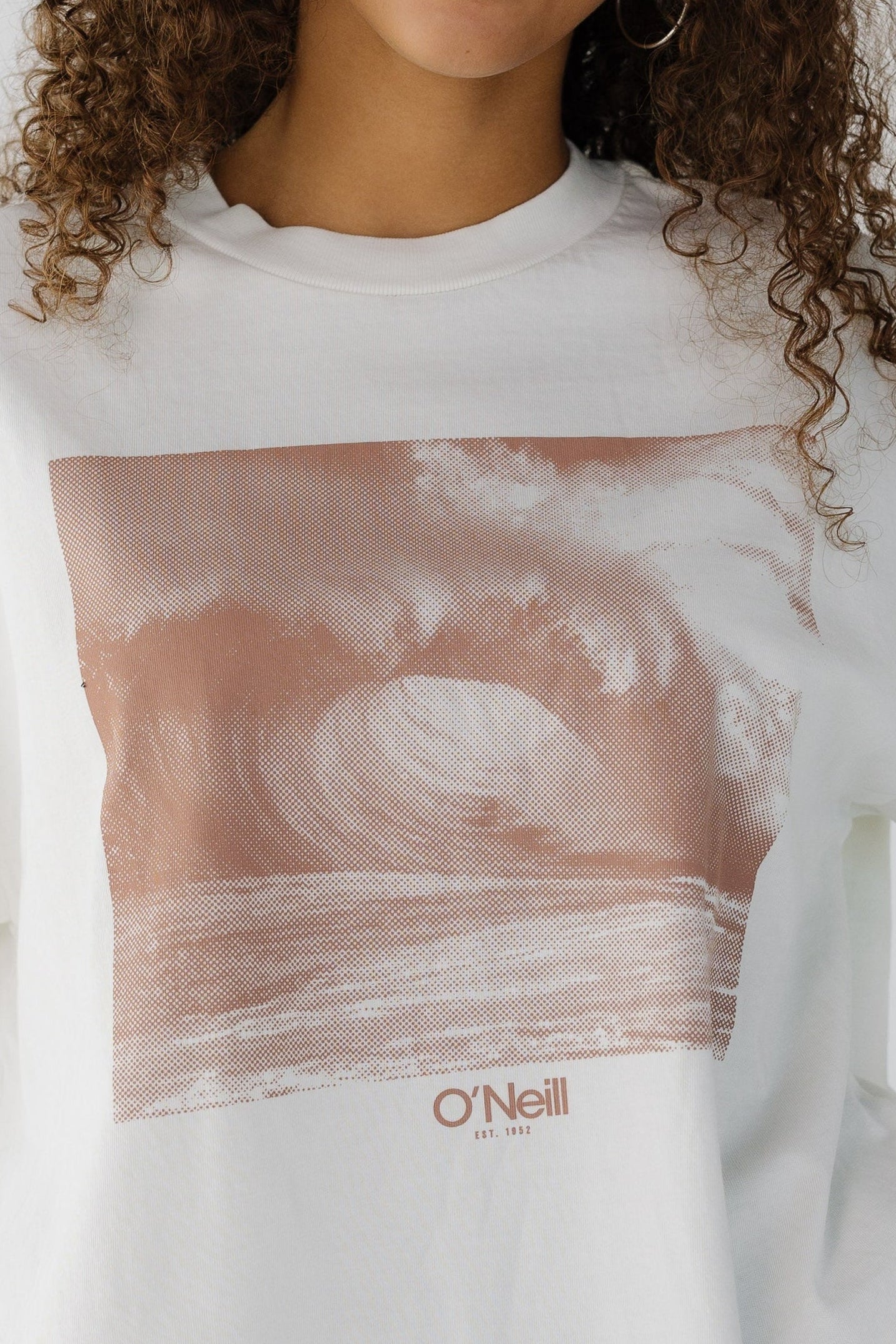 Close view of a woman wearing a large brown front wave graphic. 