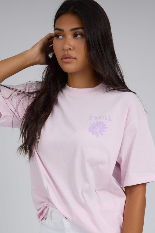 Young woman wearing a modest light pink short sleeve tee with a small front graphic.