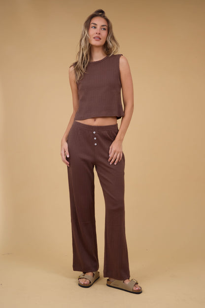 A young woman wearing a pair of wide leg brown pointelle pants with a matching Soft Knit Pointelle Knit Tank.