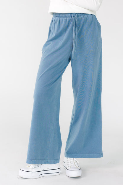Woman wearing a pair of modest blue wide leg pants with drawstring-elastic waistband.