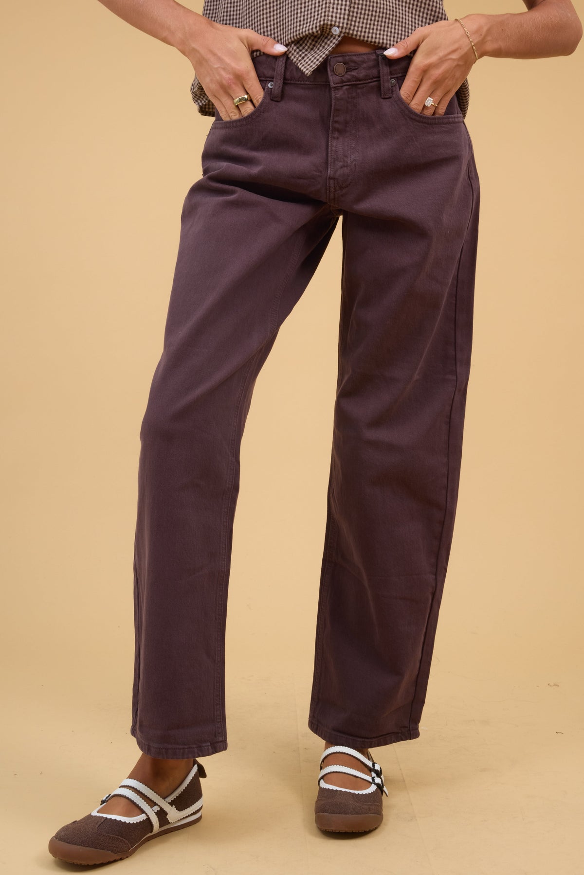 Young woman wearing a modest pair of brown wide leg barrel jeans.