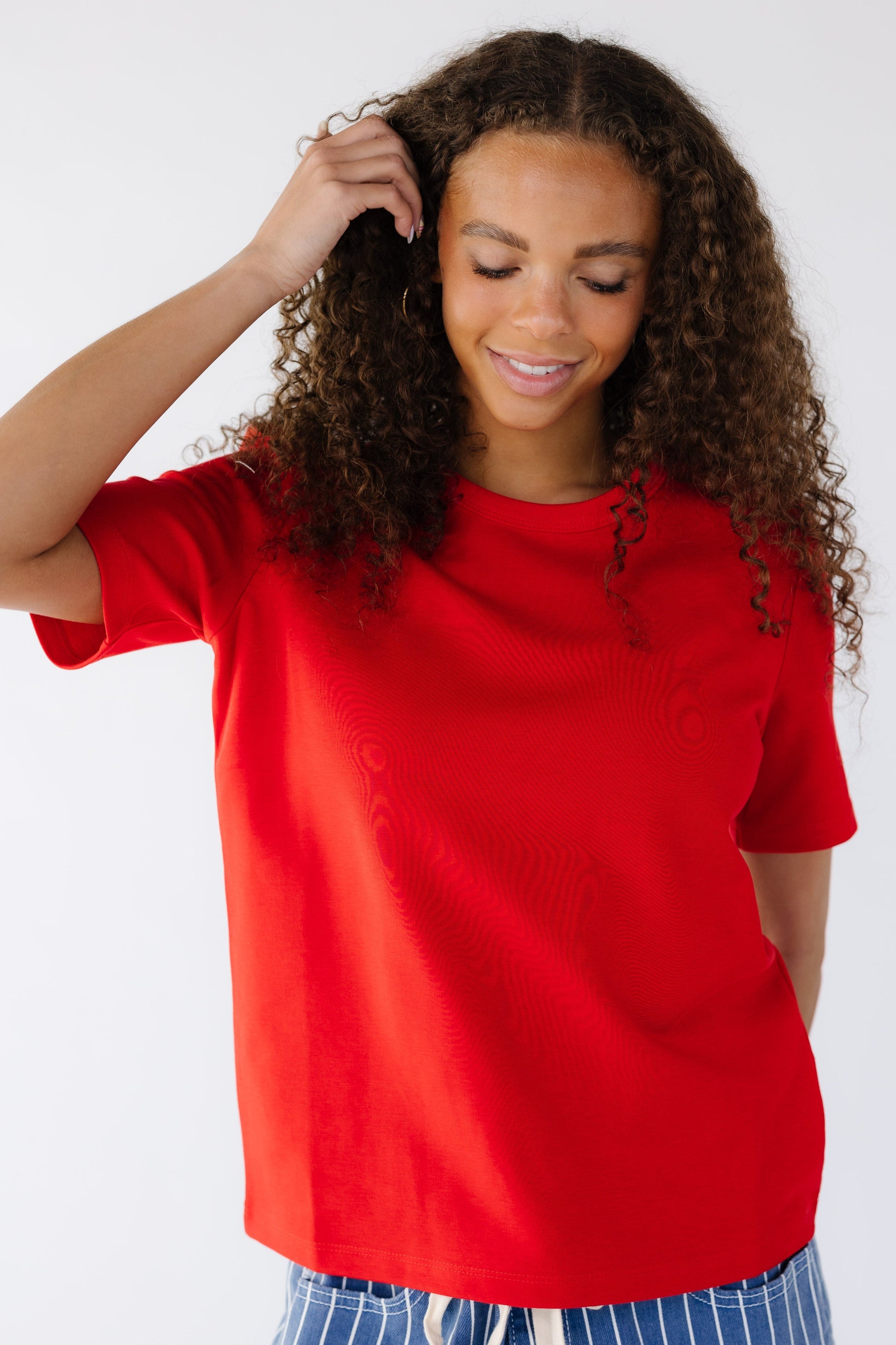 Young woman wearing a a red classic loose fitting tee with short sleeves.