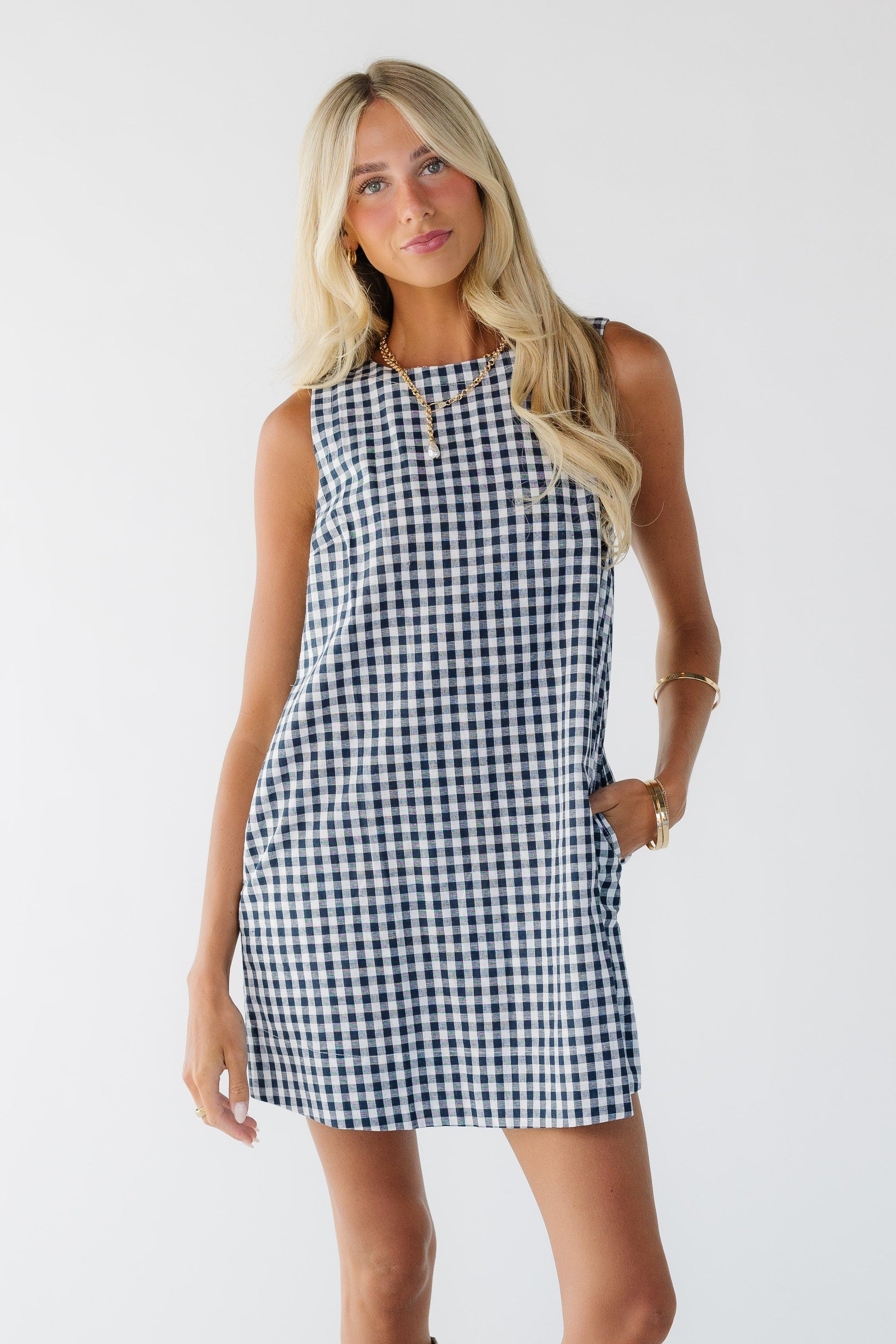 Young woman wearing a navy & white short shift dress with a round neckline.