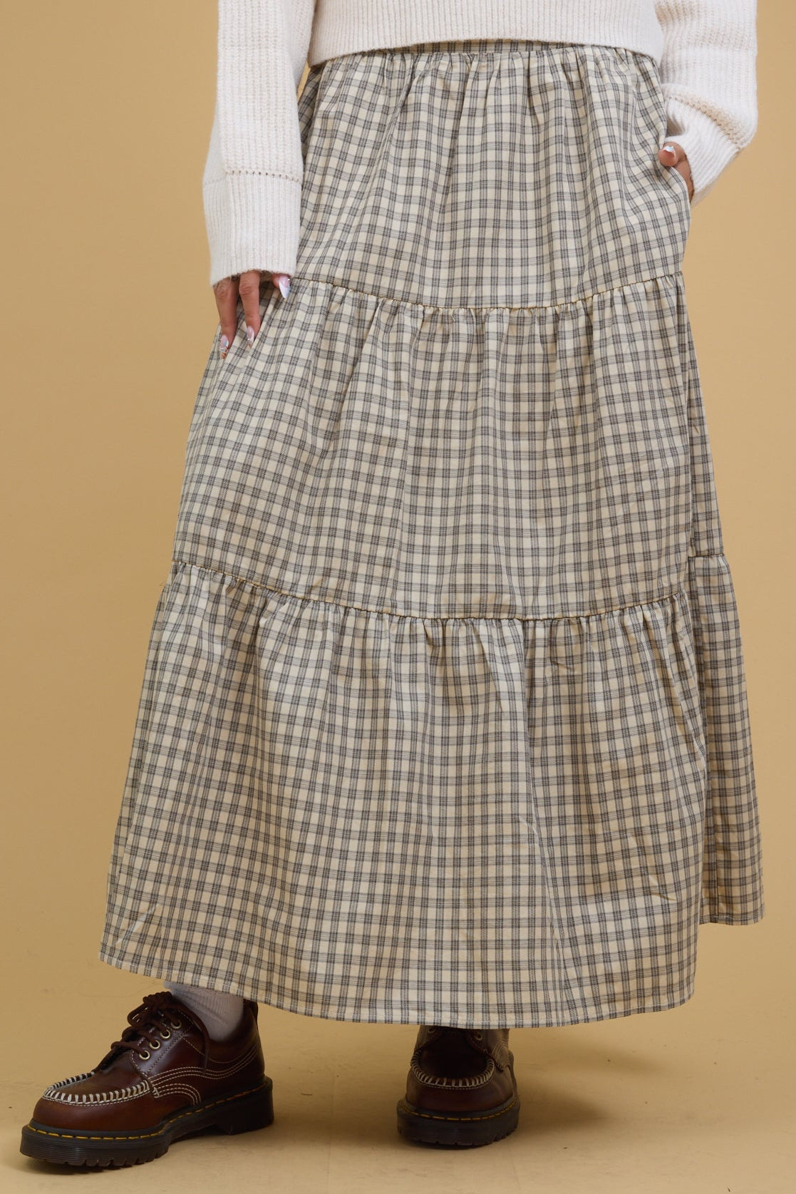 Young woman wearing a tiered midi-maxi skirt in stone & black plaid.