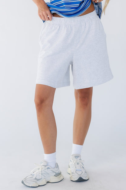 Young woman wearing a pair of wide leg, loose fitting knit shorts with a wide elastic waist.