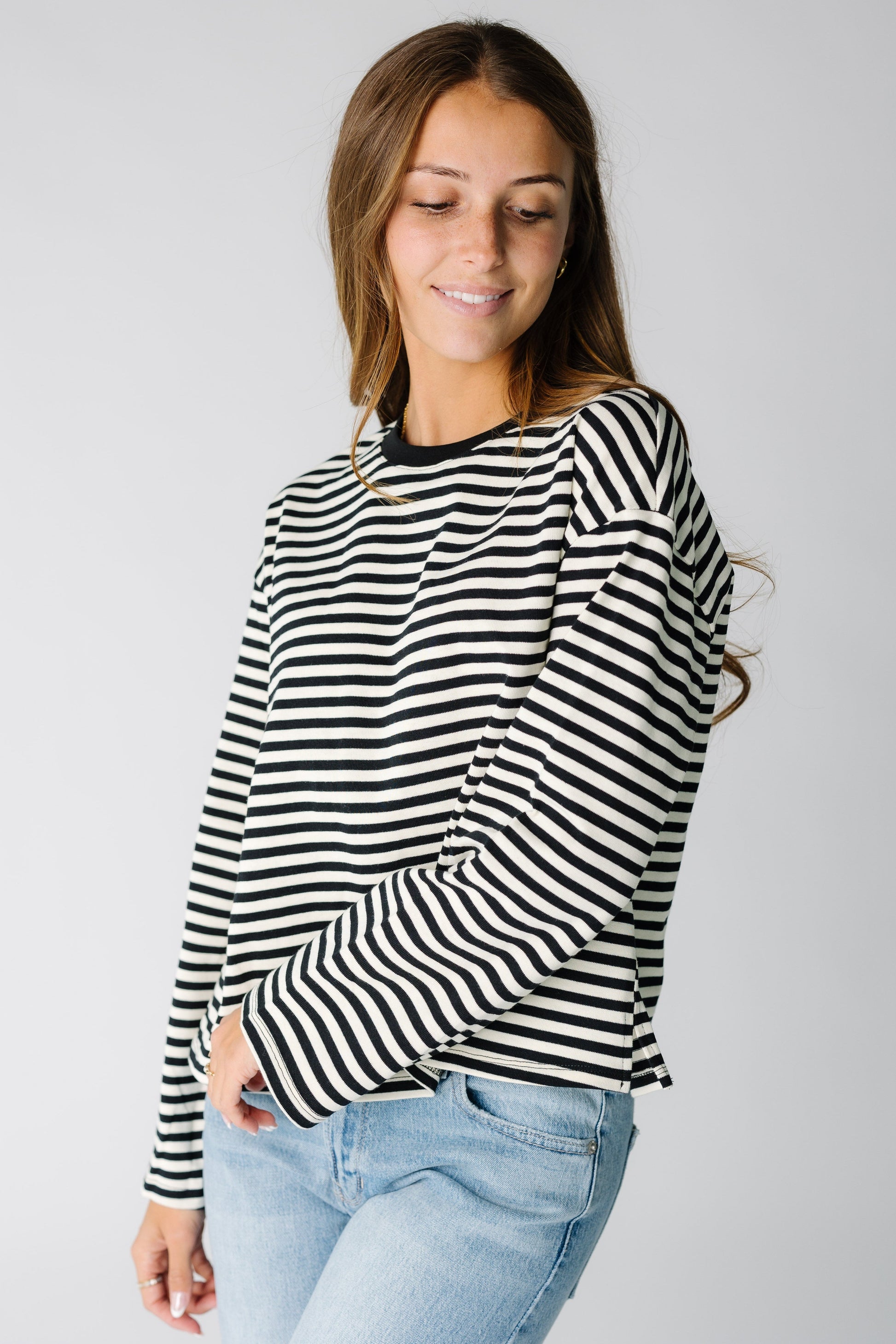 Woman wearing a modest  black and white stripe tee with a crew neckline and long sleeves