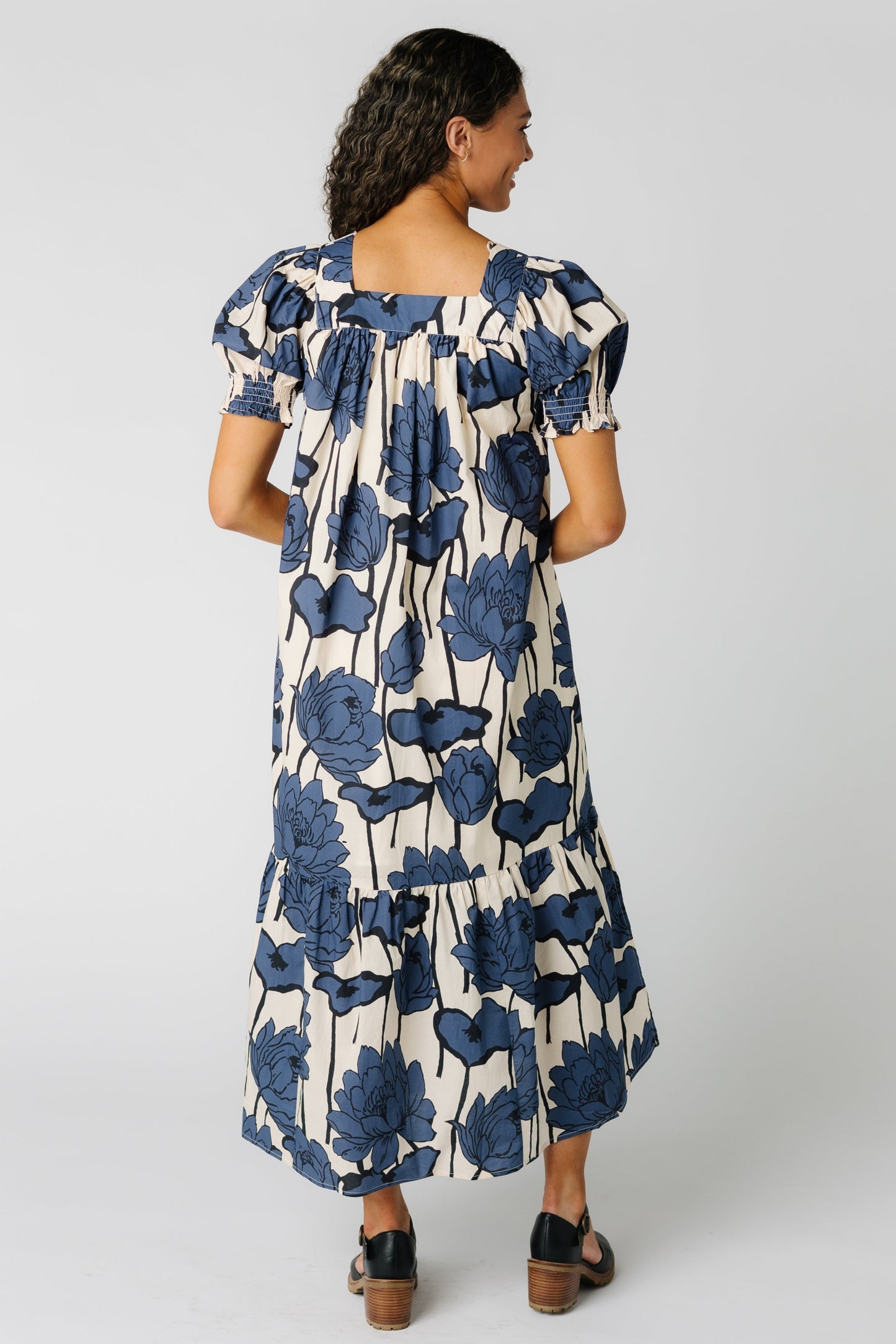 Back view of a woman wearing a blue floral dress