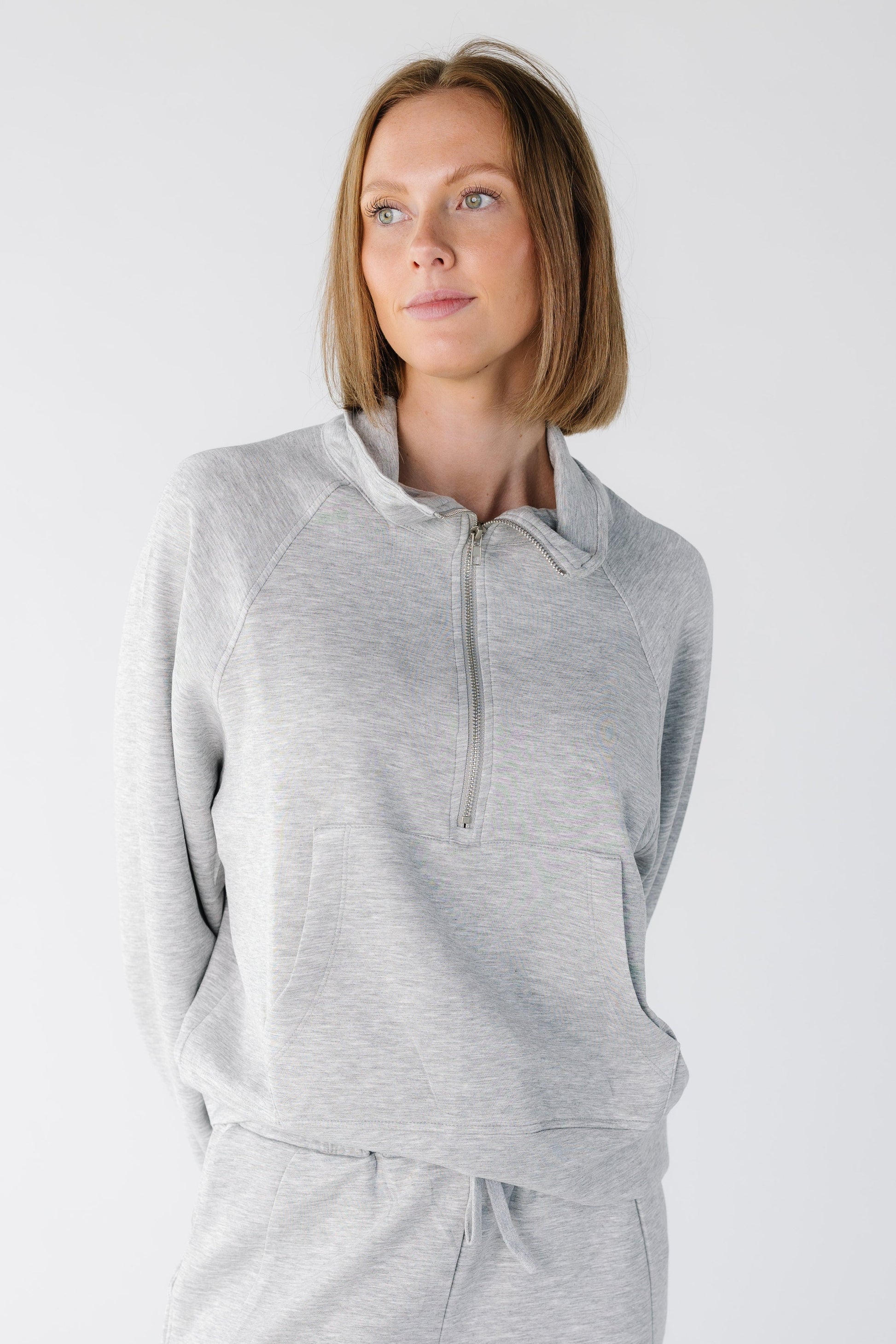 Close view of a woman wearing a long sleeve top in heather grey 