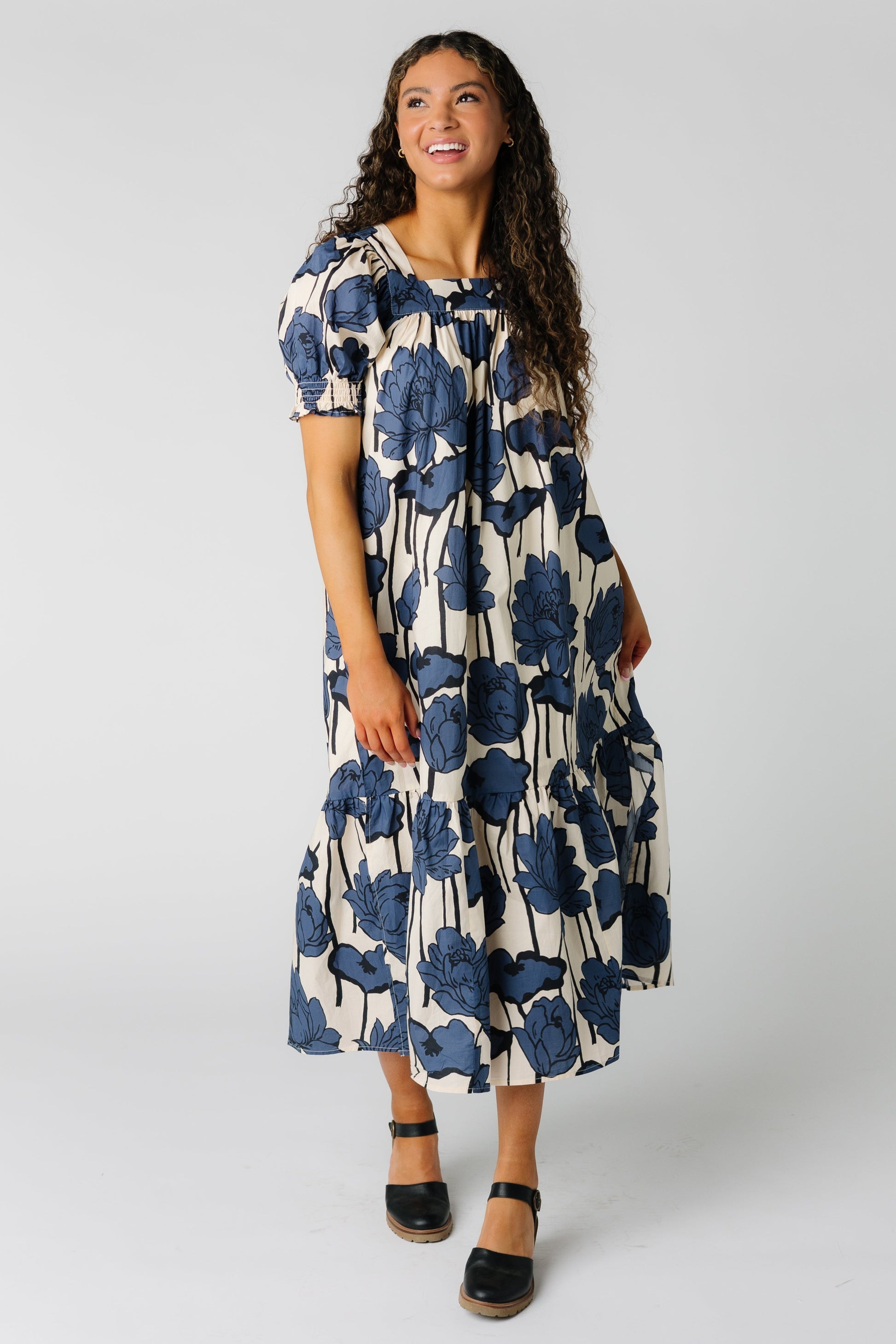 Woman wearing a cream and blue floral midi dress