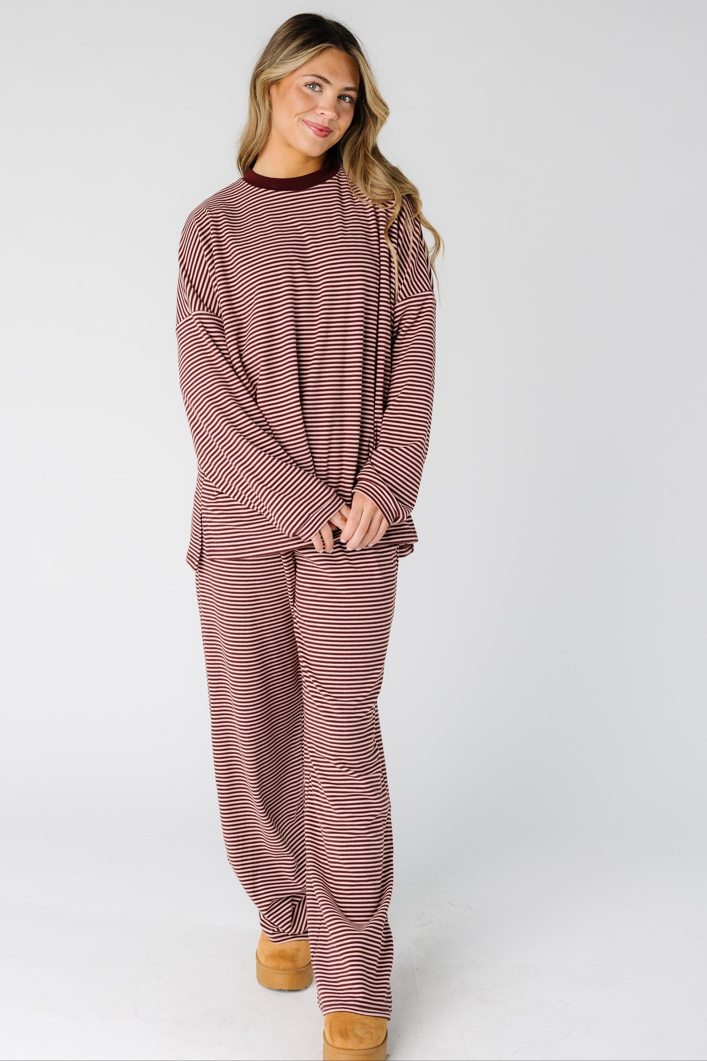 Woman wearing a modest burgundy and pink lounge set with a crew neckline, long sleeves and long length leg