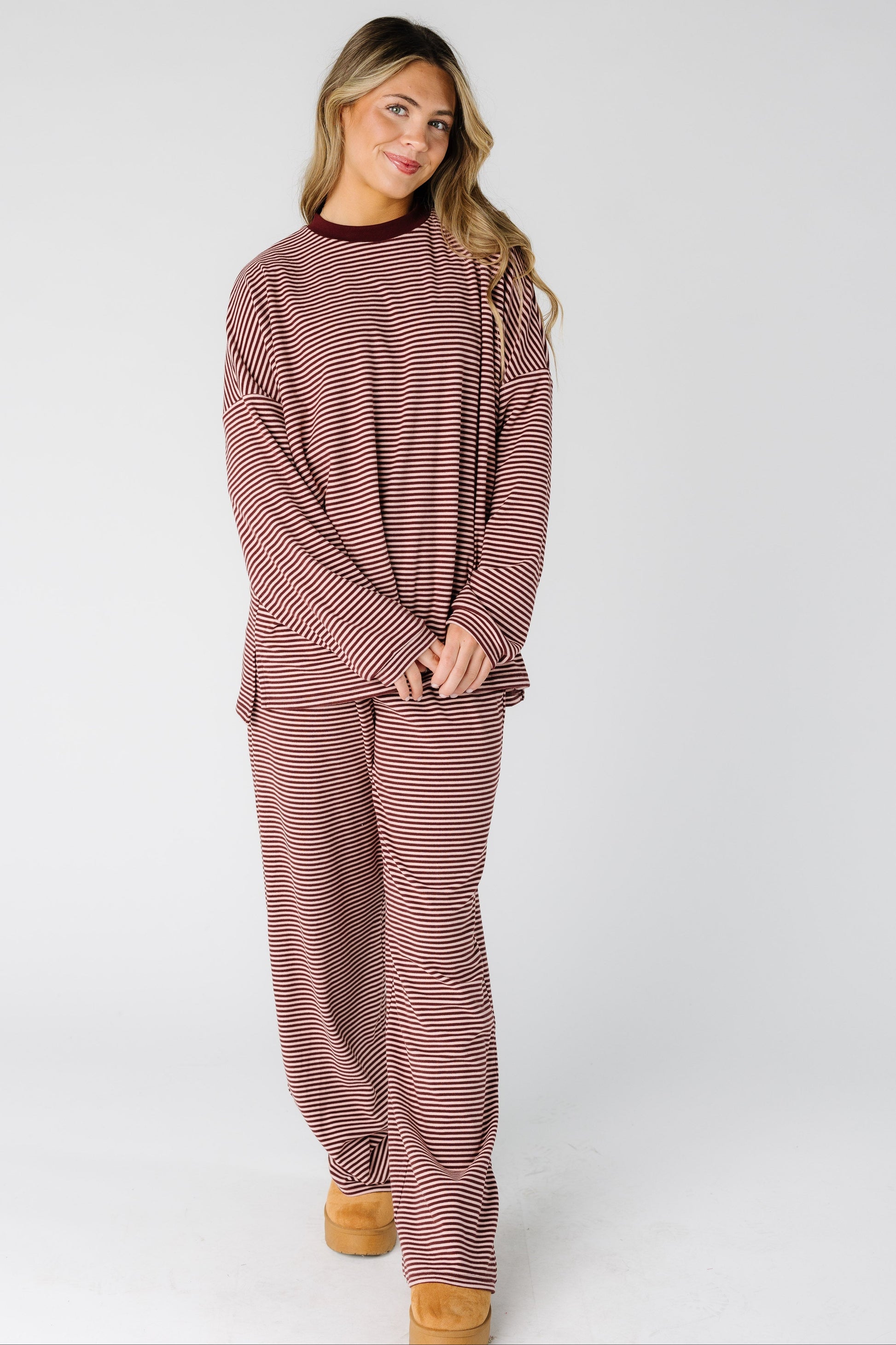 Woman wearing a modest burgundy and pink lounge set with a crew neckline, long sleeves and long length leg