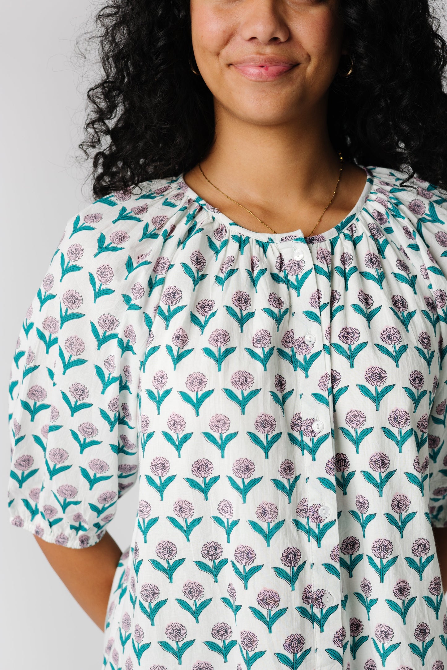 Close view of pink and teal floral button down top