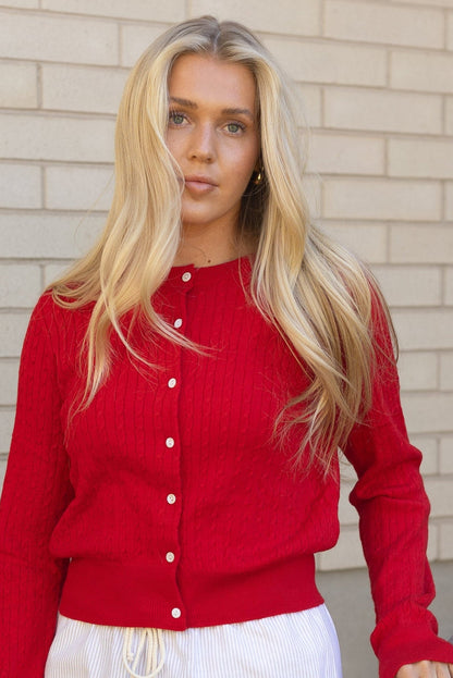 Woman wearing a red cable knit cardigan with long sleeves