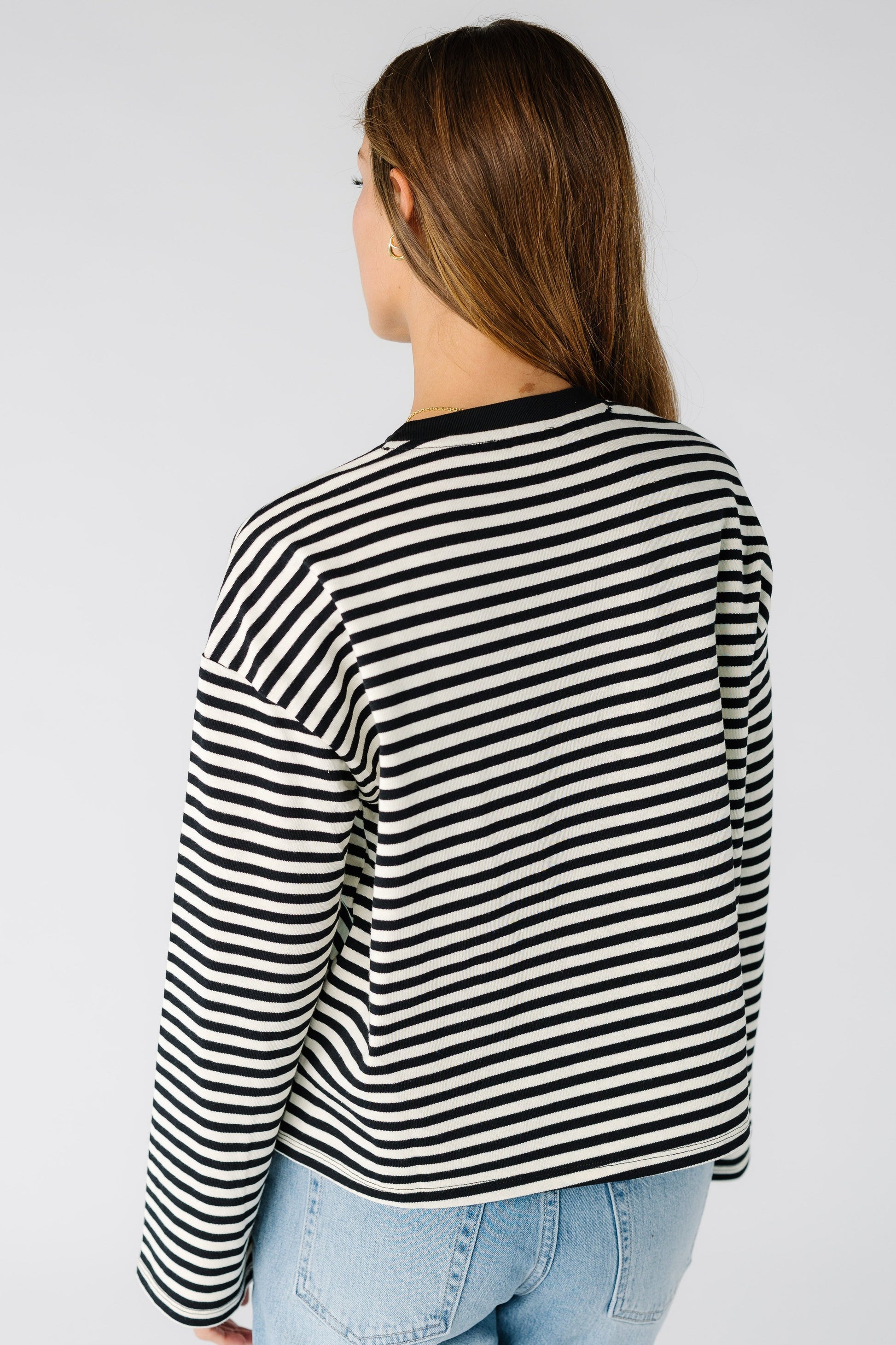 Back view of a woman wearing a black and white stripe tee with long sleeves