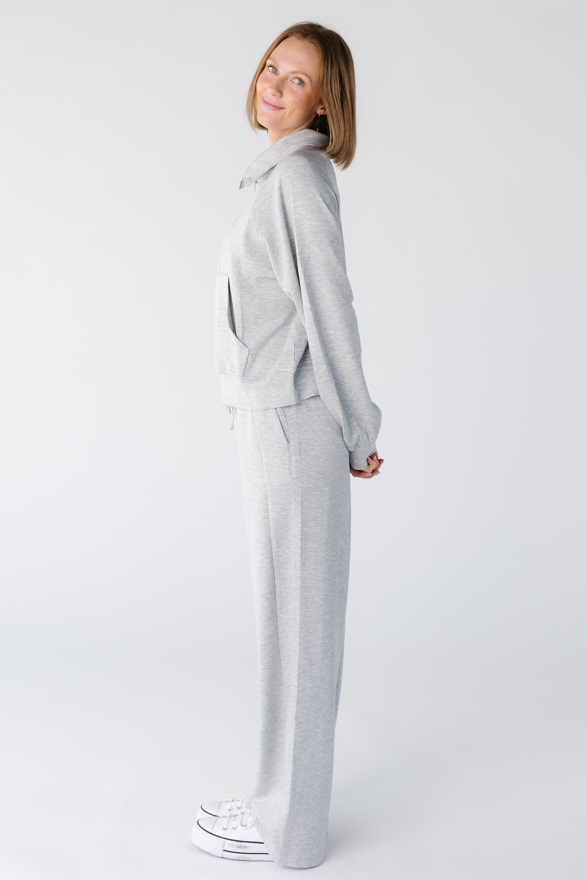 Side view of a woman wearing a heather grey lounge set with long sleeves and wide cut leg