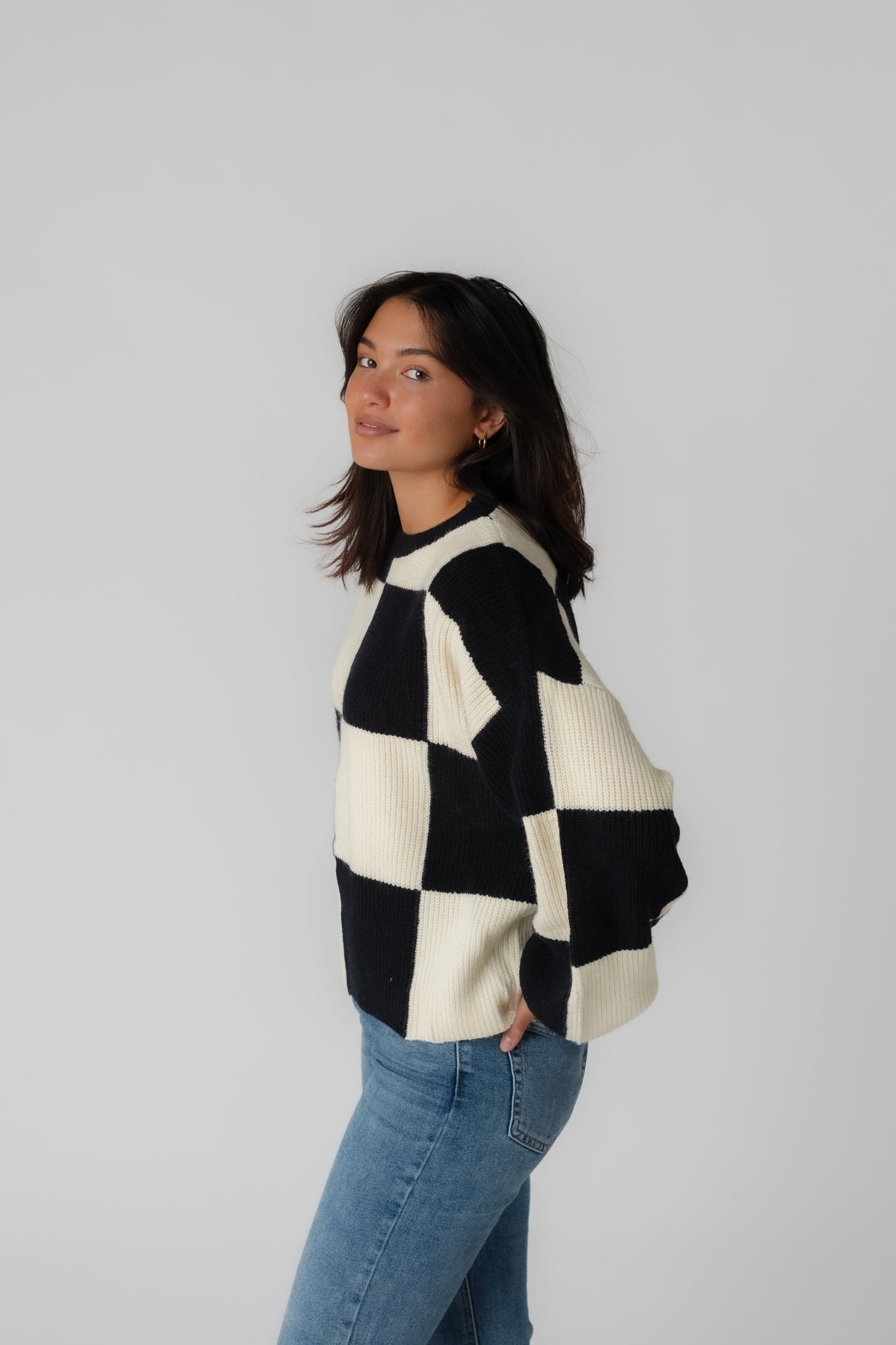 Side view of black and cream check sweater