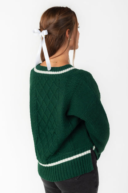 Back view of green cabled sweater with long sleees