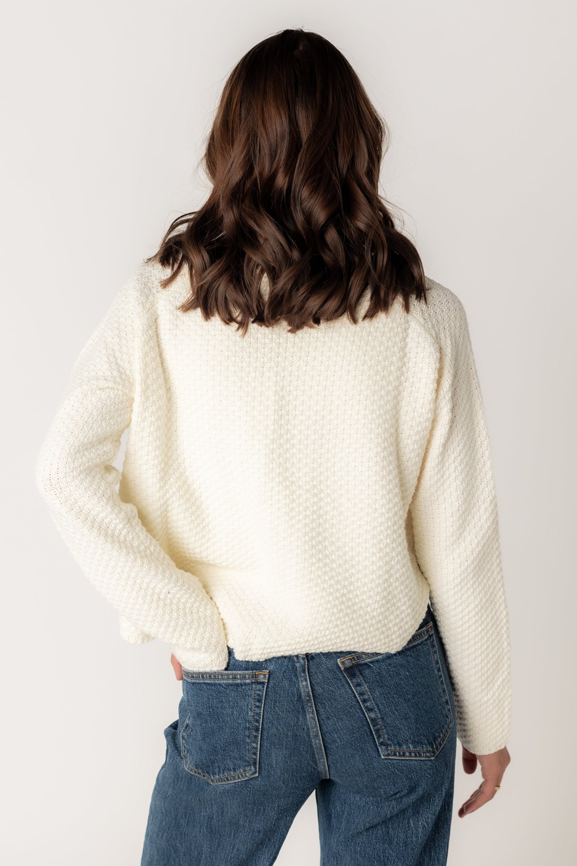 Back view of textured long sleeve cardigan with round neckline