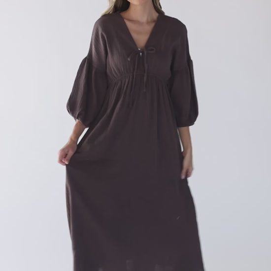 Video of a women wearing a brown midi dress with three quarter length sleeves