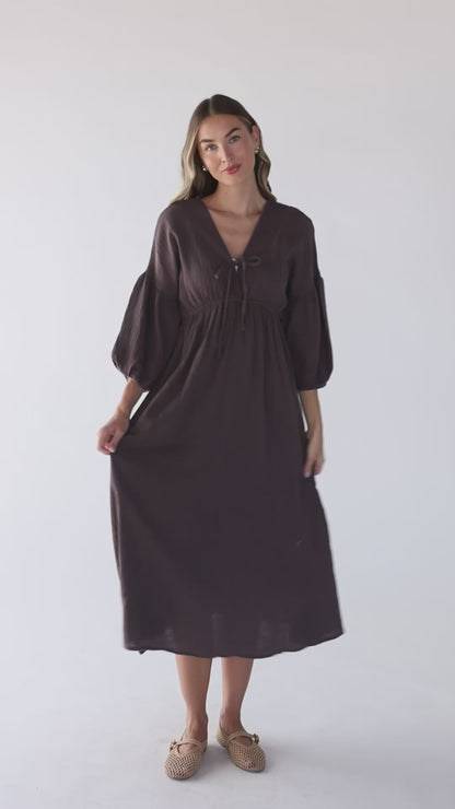 Video of a women wearing a brown midi dress with three quarter length sleeves