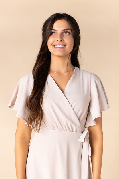 Close view of taupe wrap dress with flutter sleeves